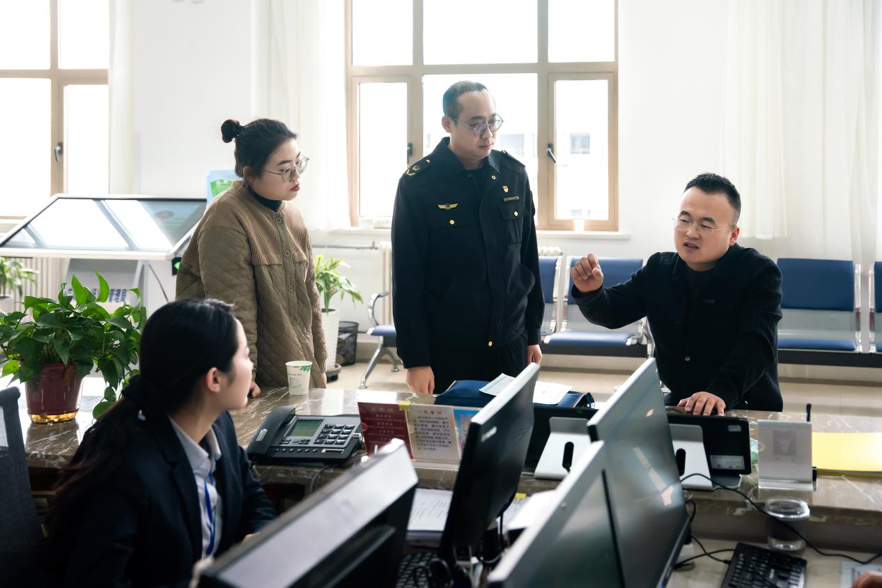 在庆阳市政务服务中心，庆阳市市场监督管理局工作人员为市民解答开办企业相关问题。王志龙 摄