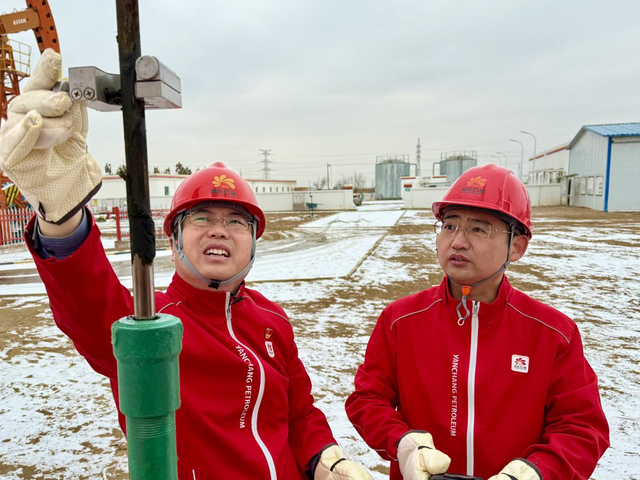 2月10日在延长油田股份有限公司定边采油厂东仁沟采油队1827井场杨浩和技术组的工友们穿梭在抽油机间逐井巡检。李德龙（摄） (2)